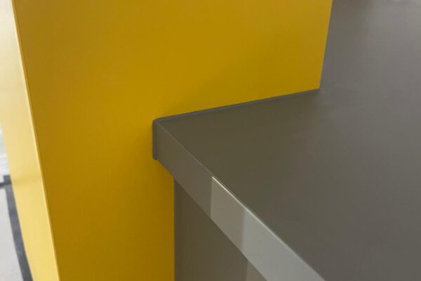 Close-up of the yellow shroud and grey worktop on the Dogs Trust Kenilworth reception desk