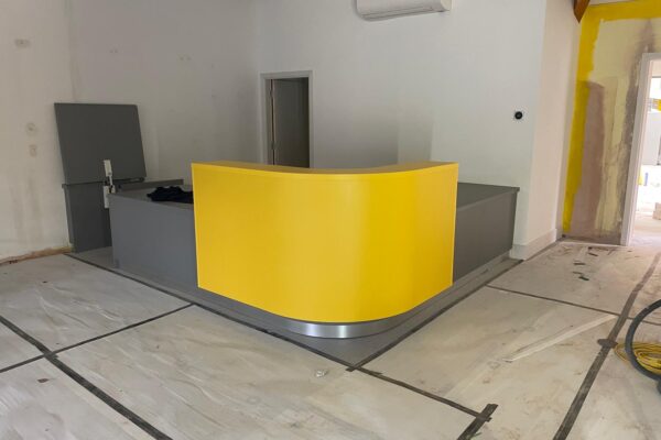 Bespoke curved yellow and grey reception desk at Dogs Trust Kenilworth